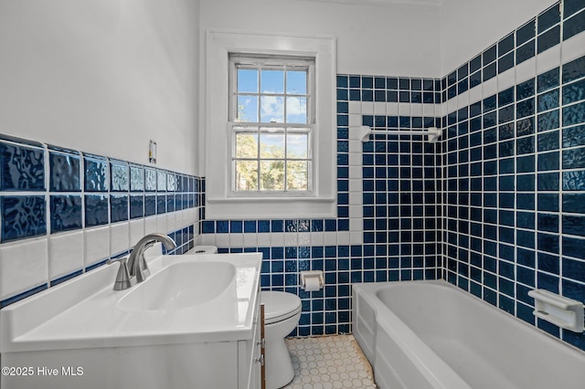 bathroom featuring tile walls, a tub to relax in, vanity, toilet, and tile patterned floors