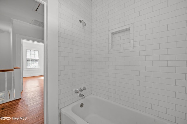 bathroom with hardwood / wood-style floors and tiled shower / bath combo