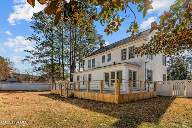 rear view of property with a yard and a deck