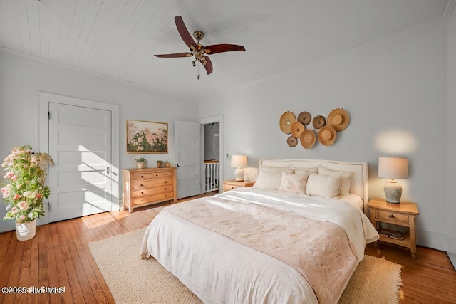 bedroom featuring crown molding, wood-type flooring, and ceiling fan