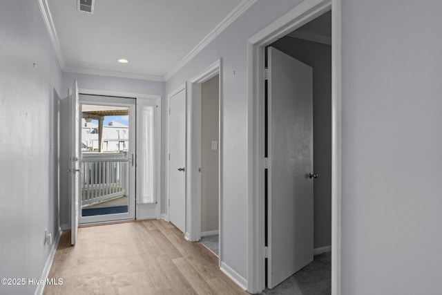 hallway featuring ornamental molding and light wood-type flooring