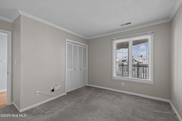 unfurnished bedroom featuring crown molding, a closet, and carpet flooring