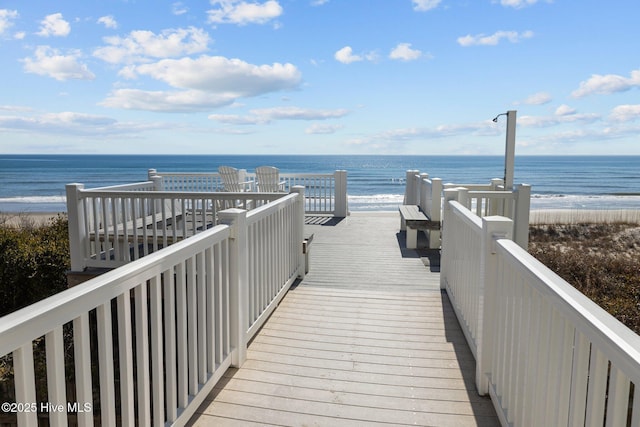 view of property's community with a water view and a view of the beach