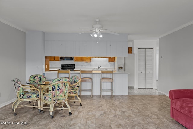 kitchen featuring crown molding, a breakfast bar, and kitchen peninsula