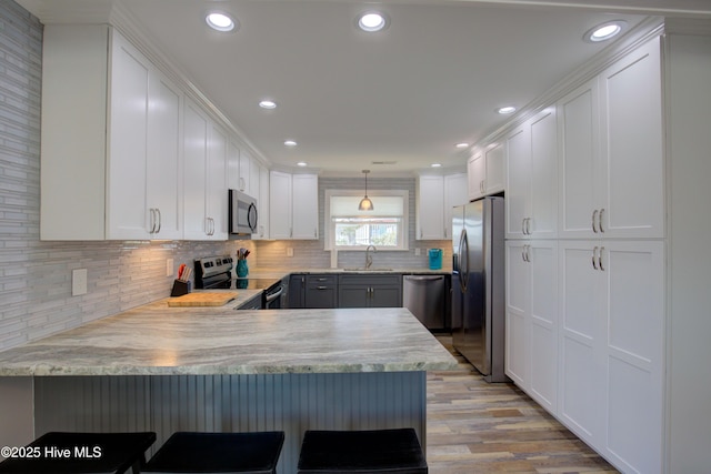 kitchen featuring kitchen peninsula, sink, and appliances with stainless steel finishes