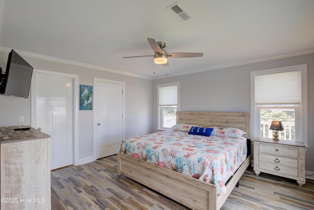 bedroom featuring crown molding, hardwood / wood-style flooring, and ceiling fan