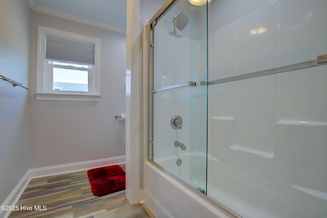 bathroom featuring bath / shower combo with glass door, wood-type flooring, and ornamental molding