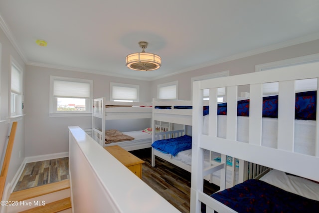 bedroom featuring crown molding, dark wood-type flooring, and multiple windows