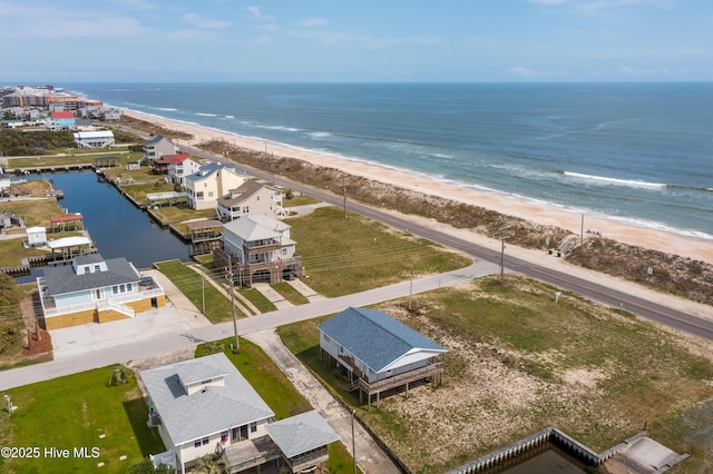 birds eye view of property featuring a water view and a beach view