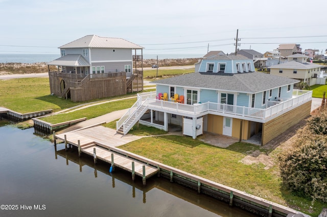 rear view of property with a patio, a lawn, and a deck with water view