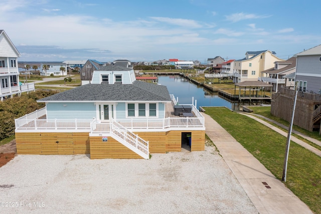 view of front of home with a front lawn and a water view