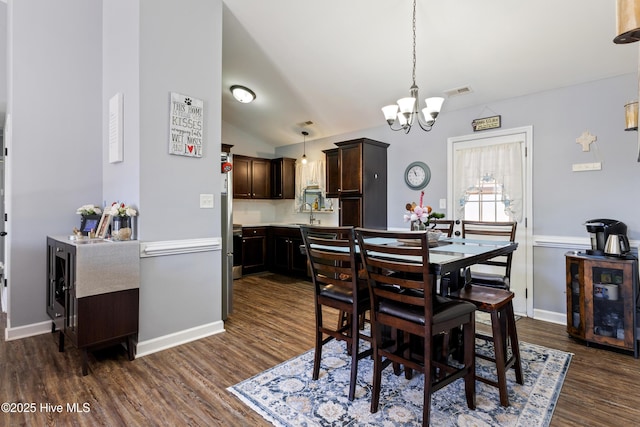 dining room featuring lofted ceiling, a notable chandelier, and dark hardwood / wood-style floors