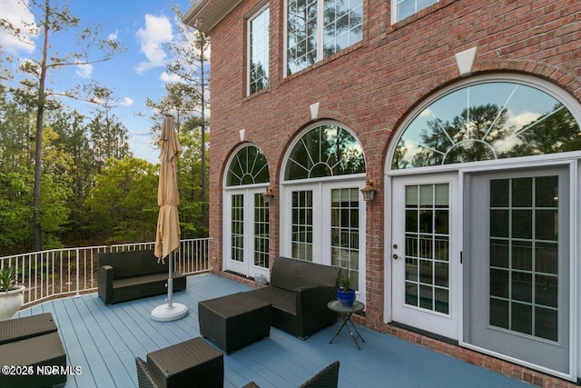 wooden deck with an outdoor hangout area and french doors