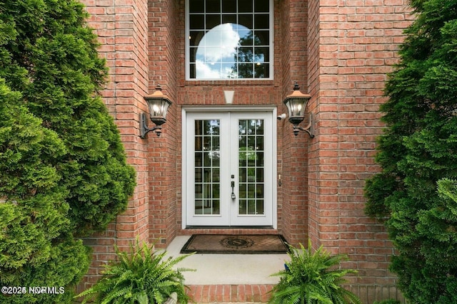 view of exterior entry with brick siding and french doors