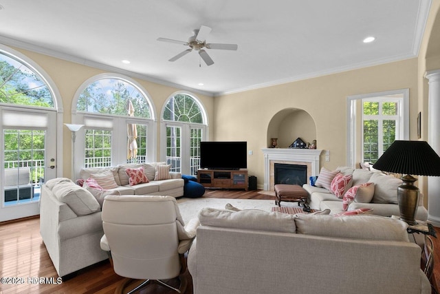 living area with ornamental molding and wood finished floors