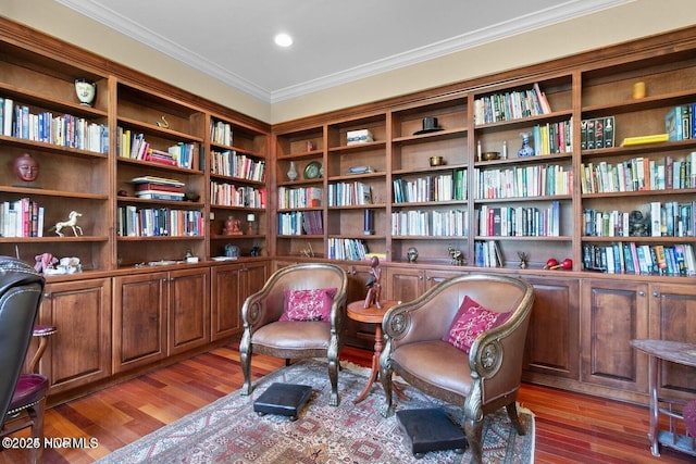 sitting room with light wood-type flooring and ornamental molding