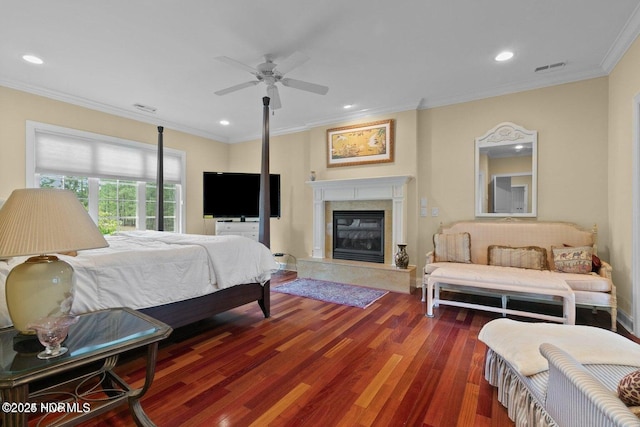 bedroom featuring recessed lighting, visible vents, a premium fireplace, ornamental molding, and wood finished floors