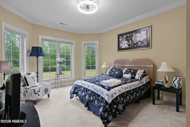 carpeted bedroom featuring ornamental molding, multiple windows, and visible vents