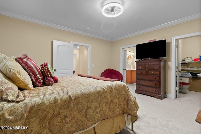 bedroom with connected bathroom, a walk in closet, crown molding, and light colored carpet