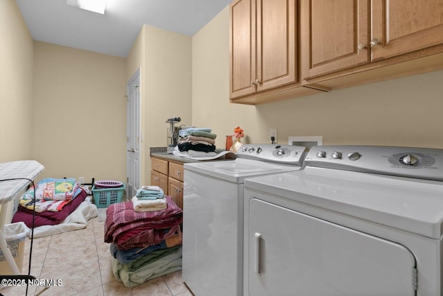 laundry area with cabinet space, washing machine and dryer, and light tile patterned floors