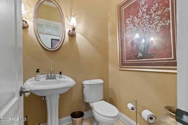 half bathroom featuring toilet and baseboards