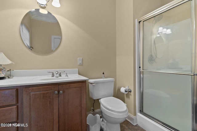 bathroom with toilet, a stall shower, baseboards, and vanity