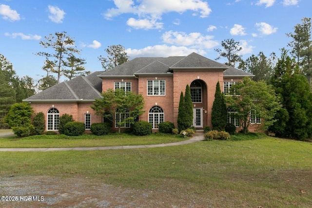 georgian-style home with brick siding and a front lawn