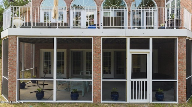 rear view of property with a sunroom and brick siding