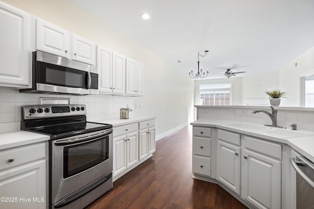 kitchen featuring appliances with stainless steel finishes, decorative backsplash, white cabinets, sink, and dark hardwood / wood-style floors