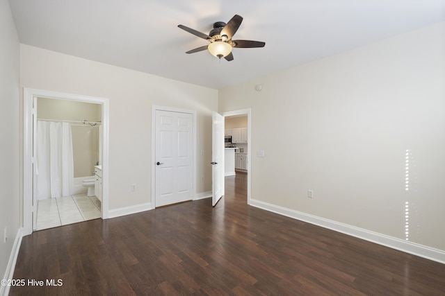 unfurnished bedroom featuring ceiling fan, hardwood / wood-style floors, and ensuite bath