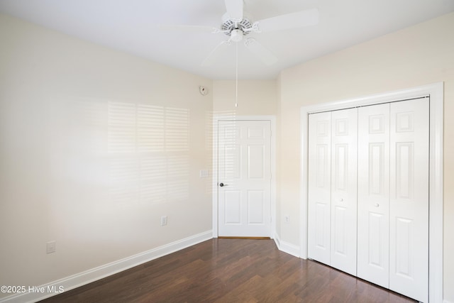 unfurnished bedroom with a closet, ceiling fan, and dark wood-type flooring