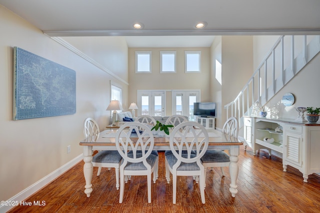 dining area with hardwood / wood-style flooring and a high ceiling