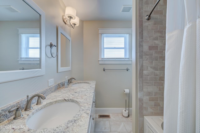 bathroom with tile patterned floors, shower / bath combo with shower curtain, and vanity