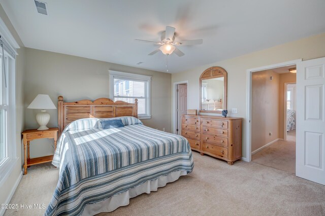 bedroom with light carpet, a closet, ceiling fan, and a water view