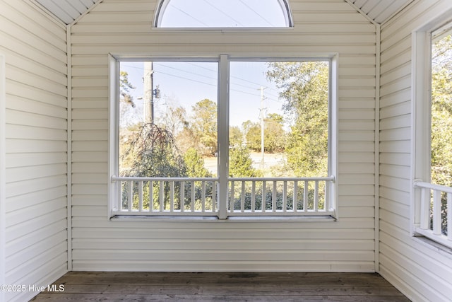 unfurnished sunroom featuring vaulted ceiling and a healthy amount of sunlight