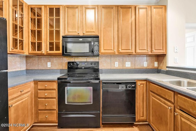 kitchen featuring light hardwood / wood-style flooring, decorative backsplash, and black appliances