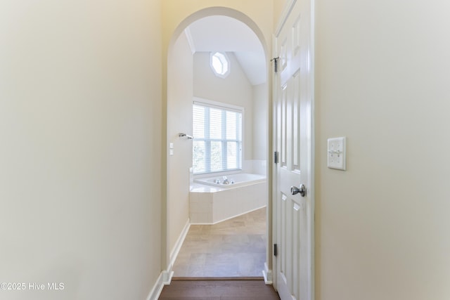 hallway with hardwood / wood-style flooring and lofted ceiling