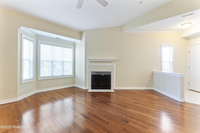 unfurnished living room featuring wood-type flooring, ornamental molding, and ceiling fan