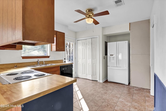 kitchen featuring sink, light tile patterned floors, stovetop, dishwasher, and white refrigerator with ice dispenser