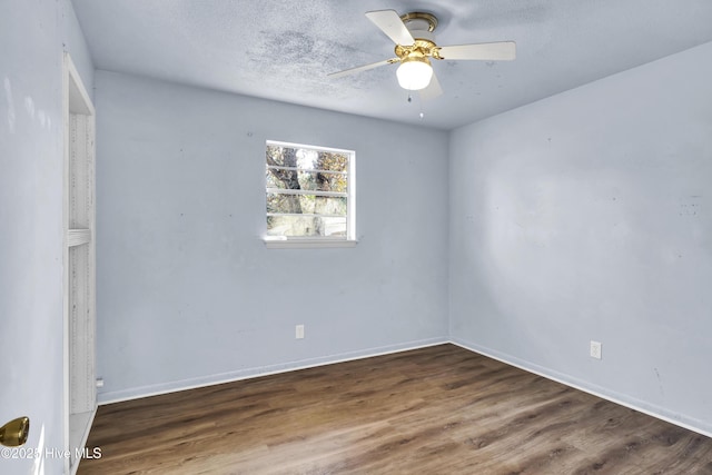 empty room with ceiling fan, dark hardwood / wood-style floors, and a textured ceiling