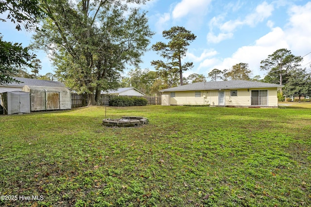 view of yard featuring an outbuilding and an outdoor fire pit