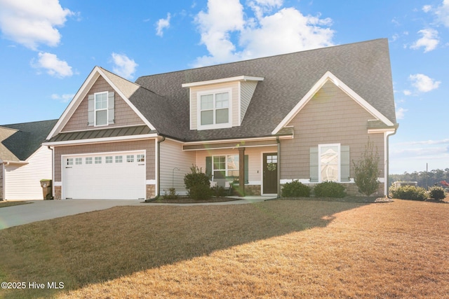 view of front of house featuring covered porch, a front yard, and a garage