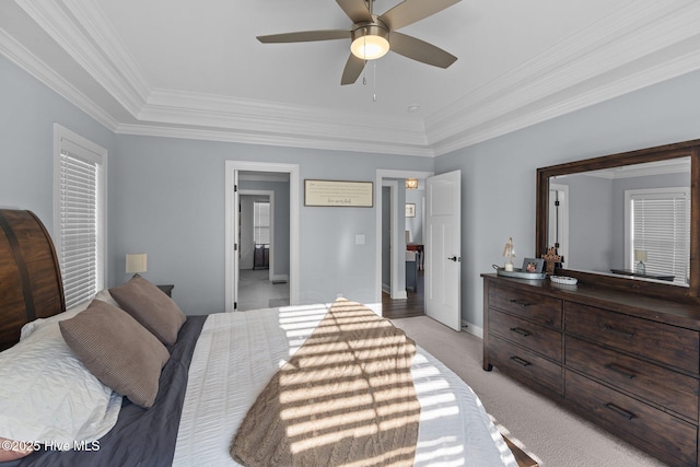 carpeted bedroom featuring ceiling fan, a tray ceiling, and crown molding