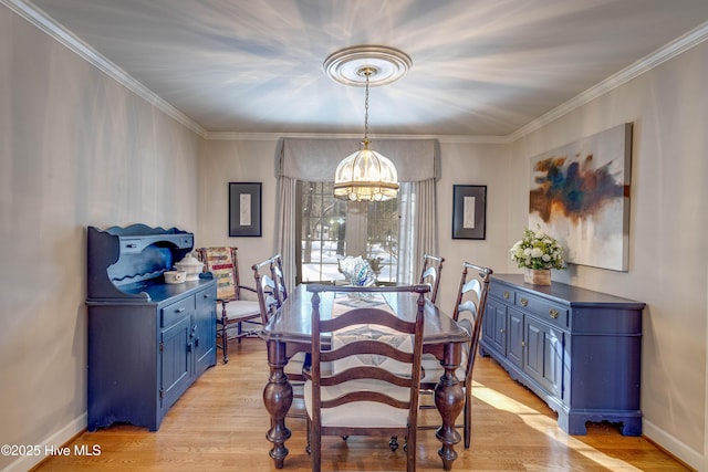 dining room featuring crown molding, a notable chandelier, and light wood-type flooring