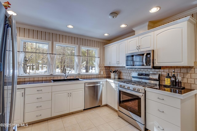 kitchen featuring stainless steel appliances, sink, decorative backsplash, and white cabinets
