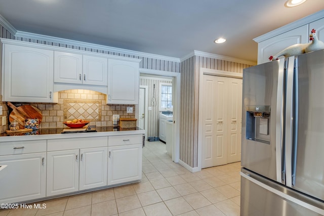 kitchen with white cabinetry, light tile patterned flooring, ornamental molding, and stainless steel refrigerator with ice dispenser