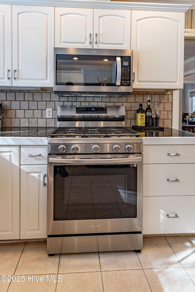 kitchen featuring light tile patterned floors, white cabinets, and appliances with stainless steel finishes