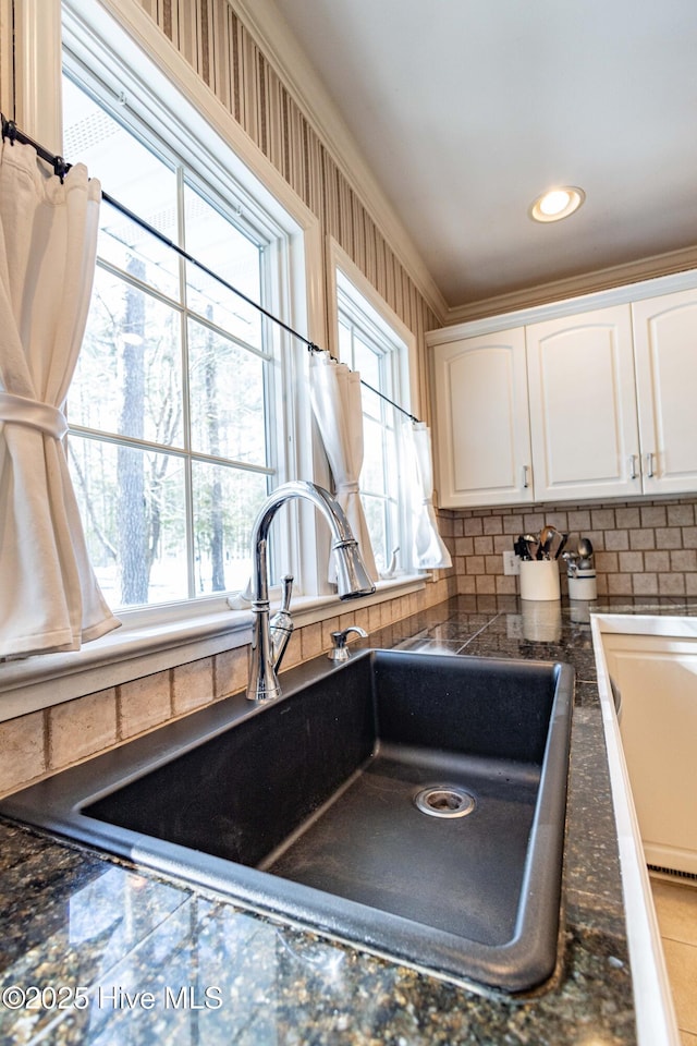 interior space with sink, ornamental molding, and white cabinets