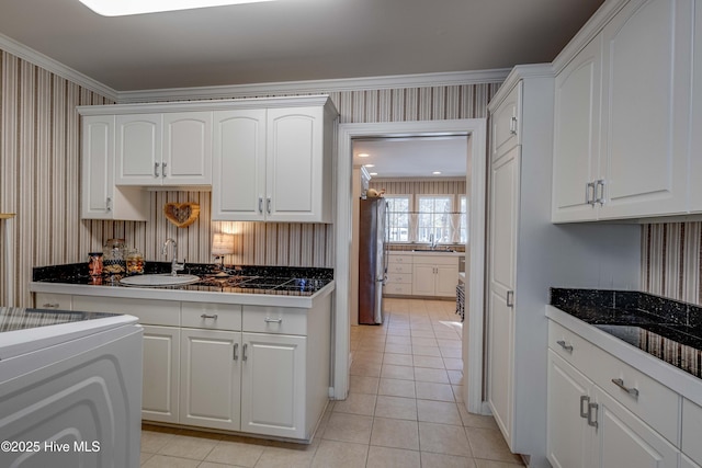 kitchen with stainless steel refrigerator, sink, and white cabinets