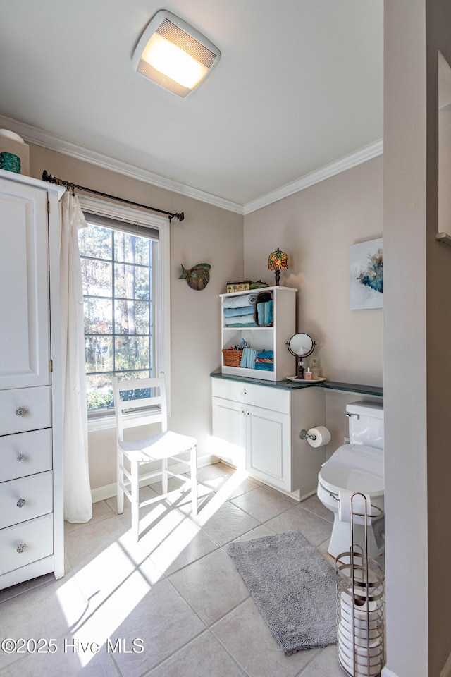 bathroom with crown molding, toilet, and tile patterned flooring